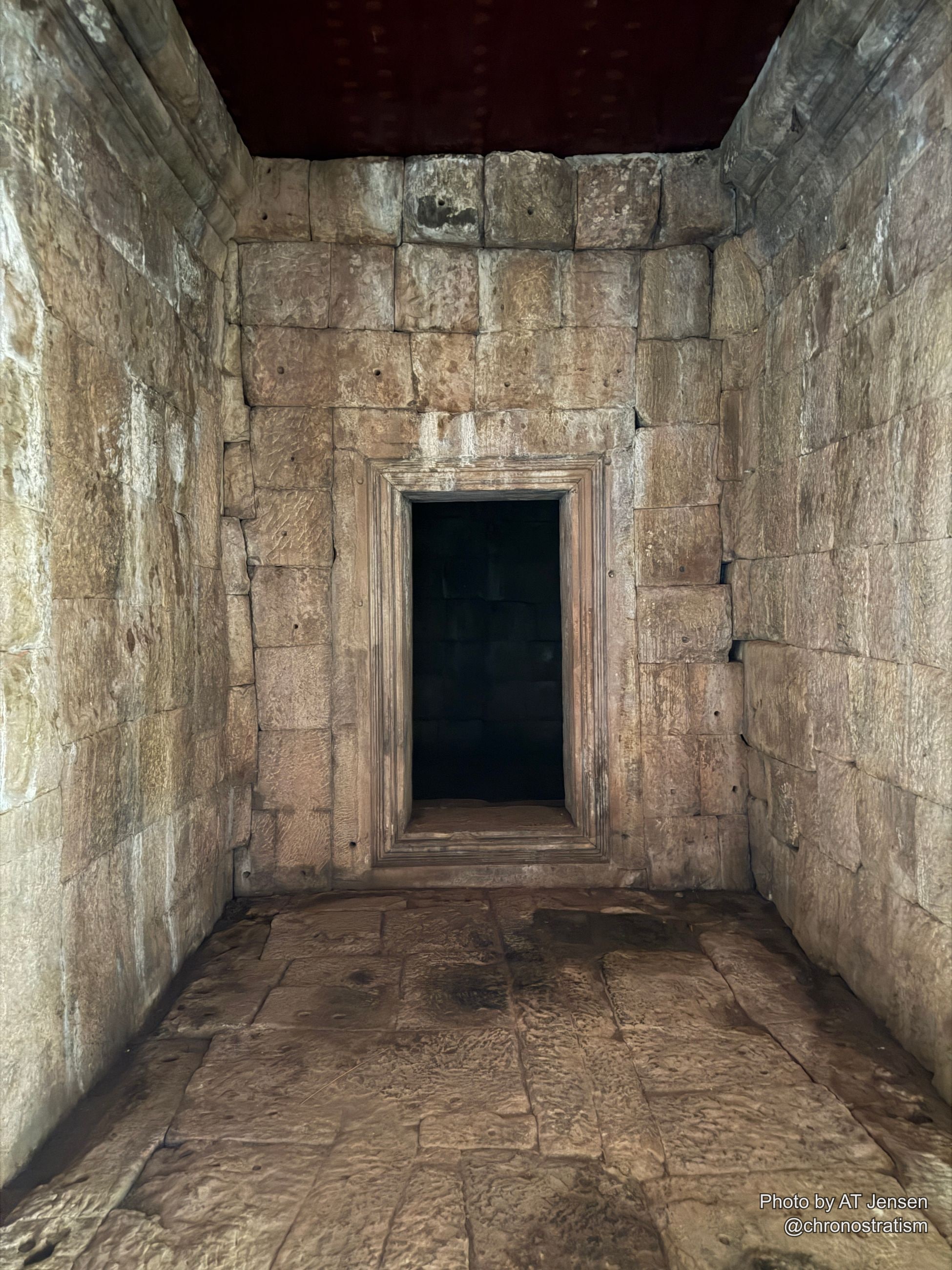 A sandstone temple chamber interior, sunlight falling through a carved window frame.