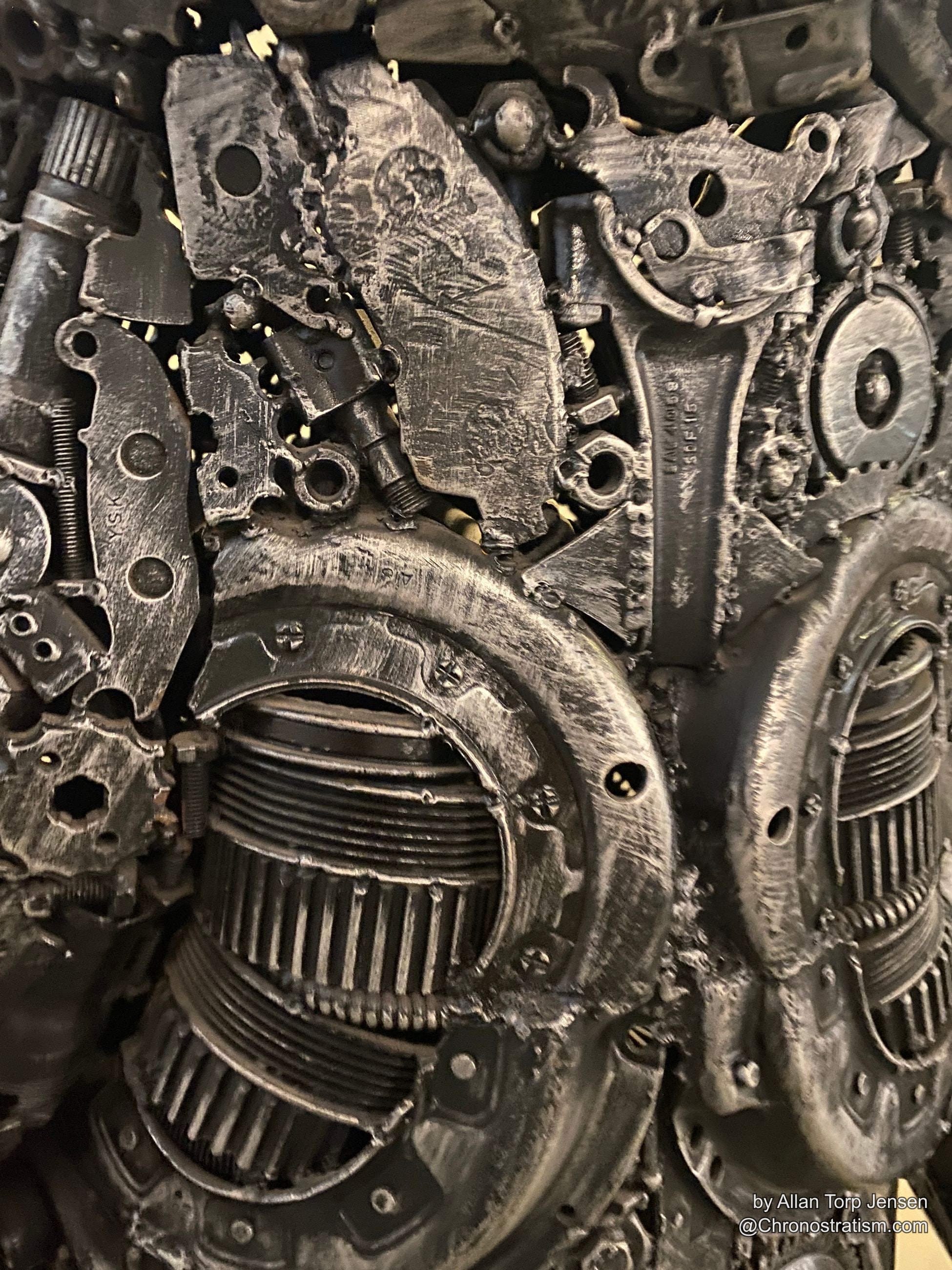 Dense cluster of dark, weathered cast-metal gears and engine housings.