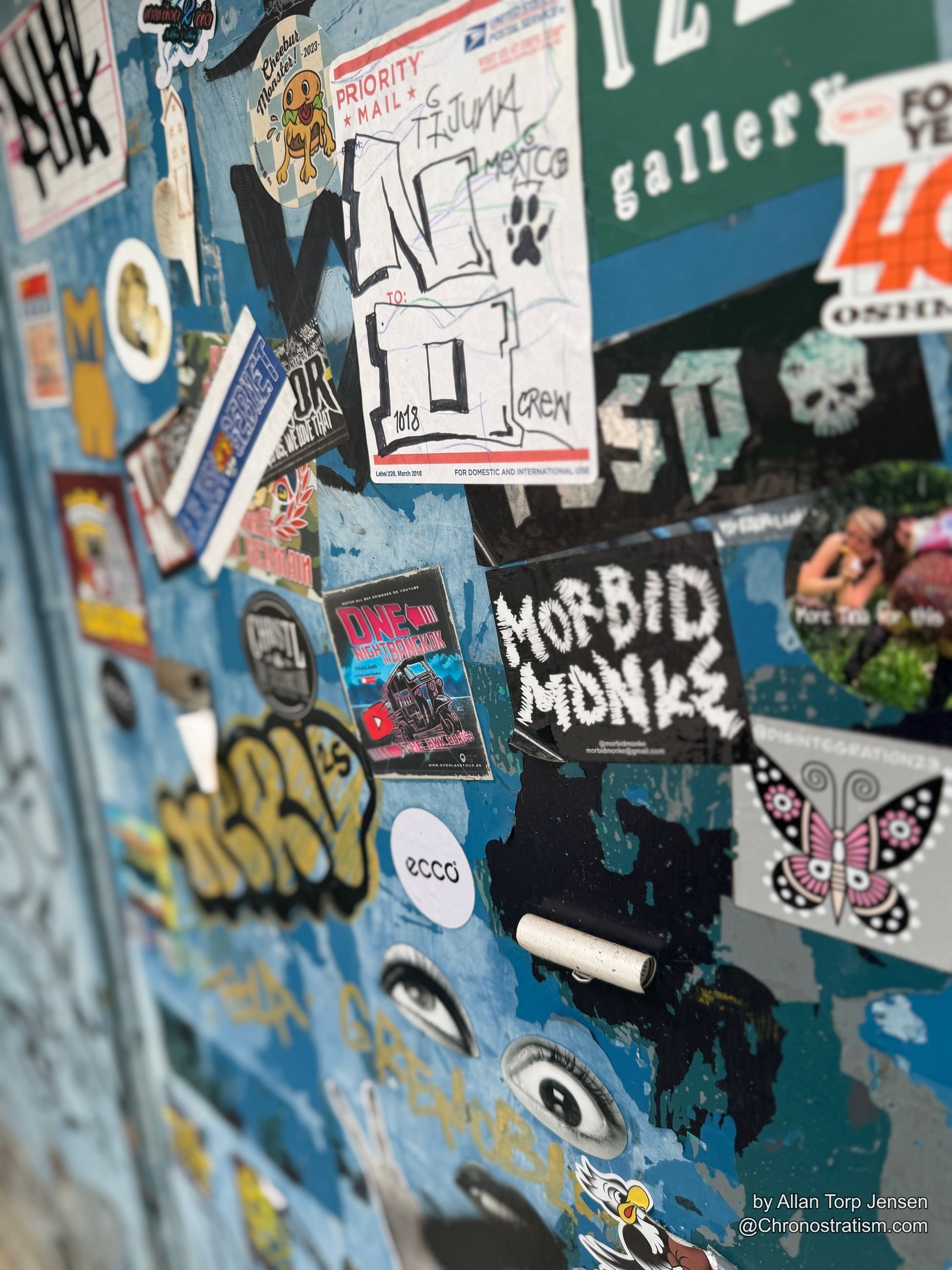 Dense sticker collage of monster and eye characters plastered over a blue-grey surface.