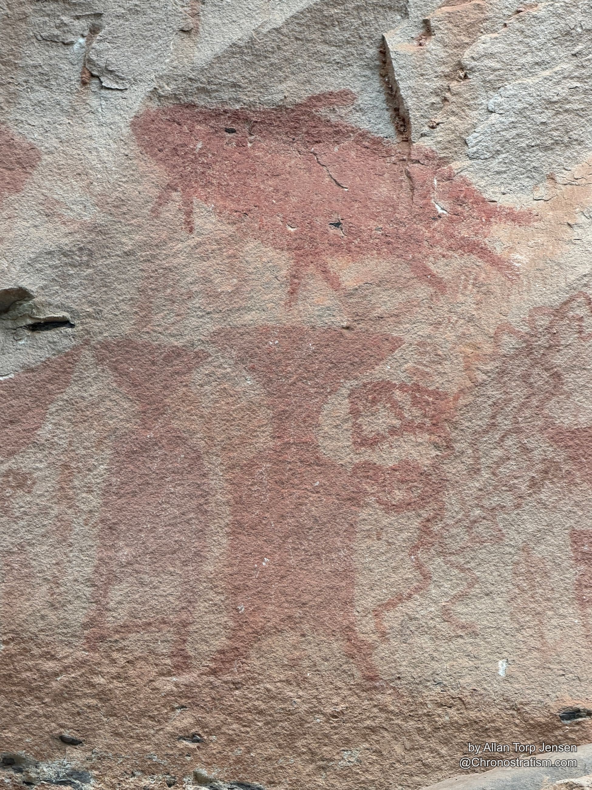Macro detail of the red pictograph symbol’s cracked, sun-bleached paint.