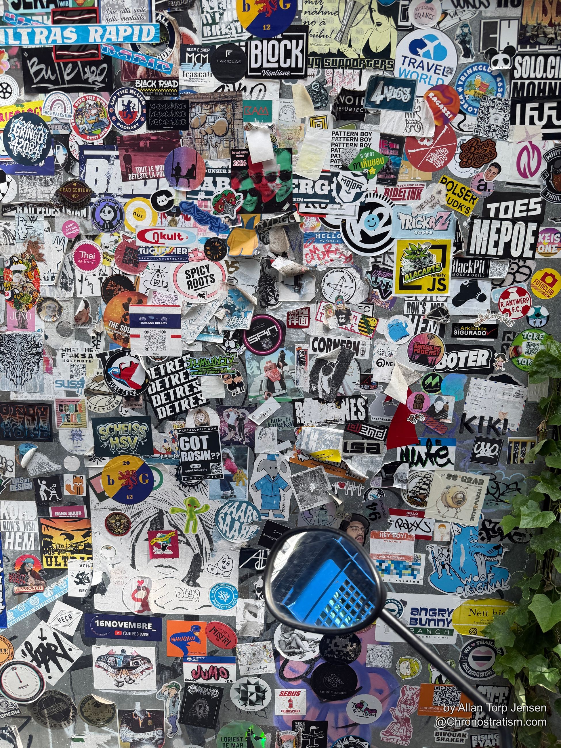 Novelty and crew stickers plastered edge to edge across weathered grey render.