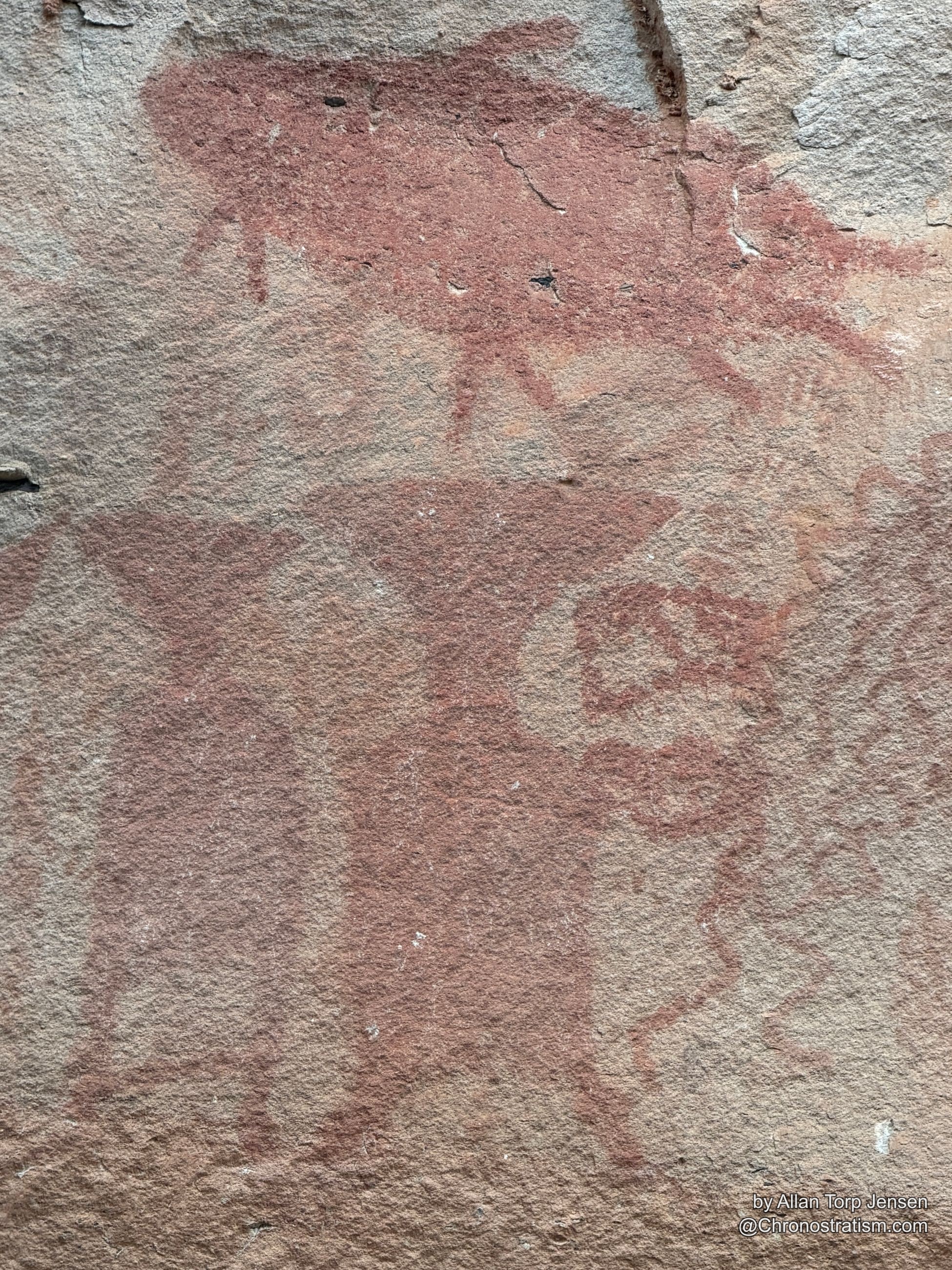 Repeating triangular pictograph shapes stamped across the stone wall.