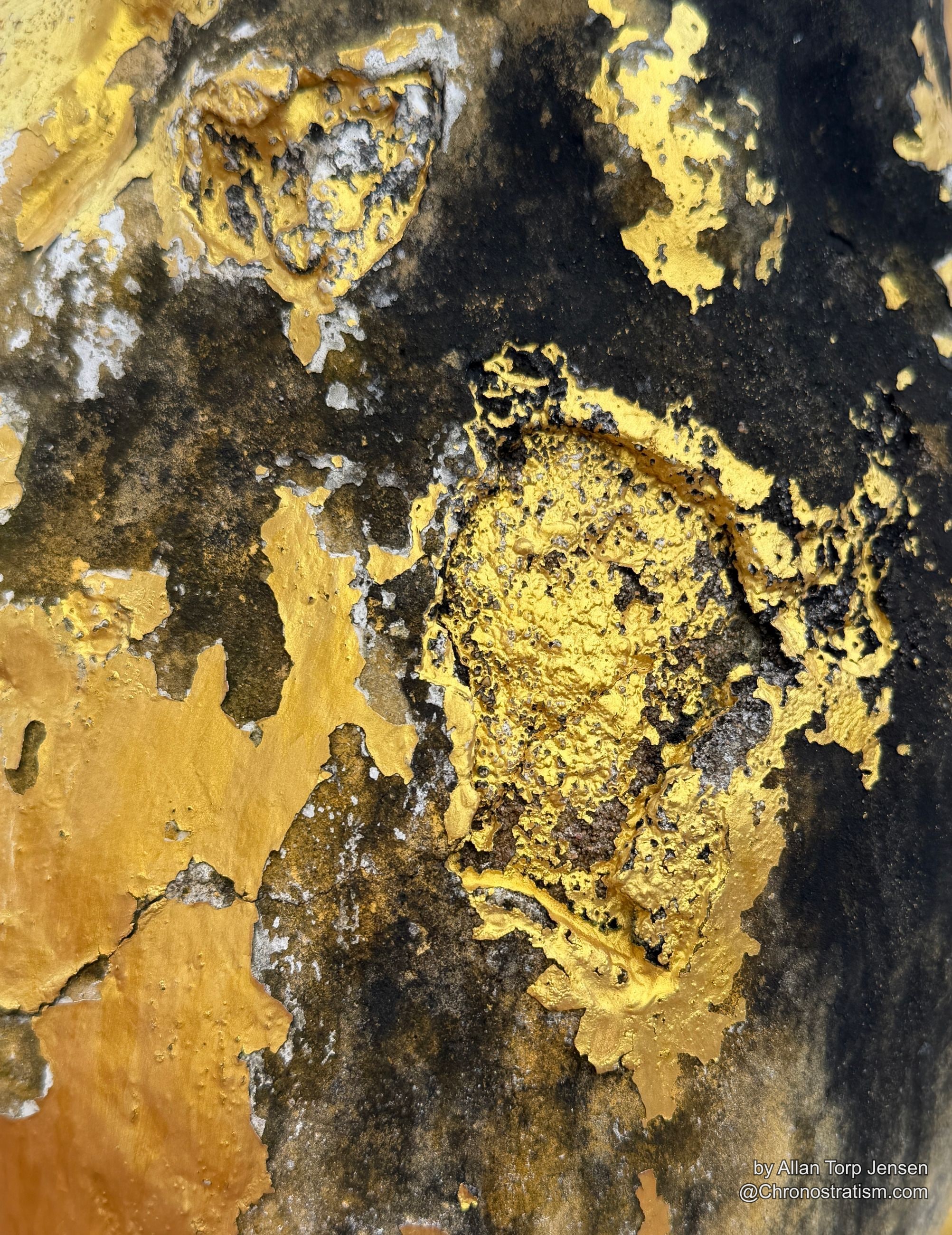Rounded gilt lumps break through a crust of black grime.