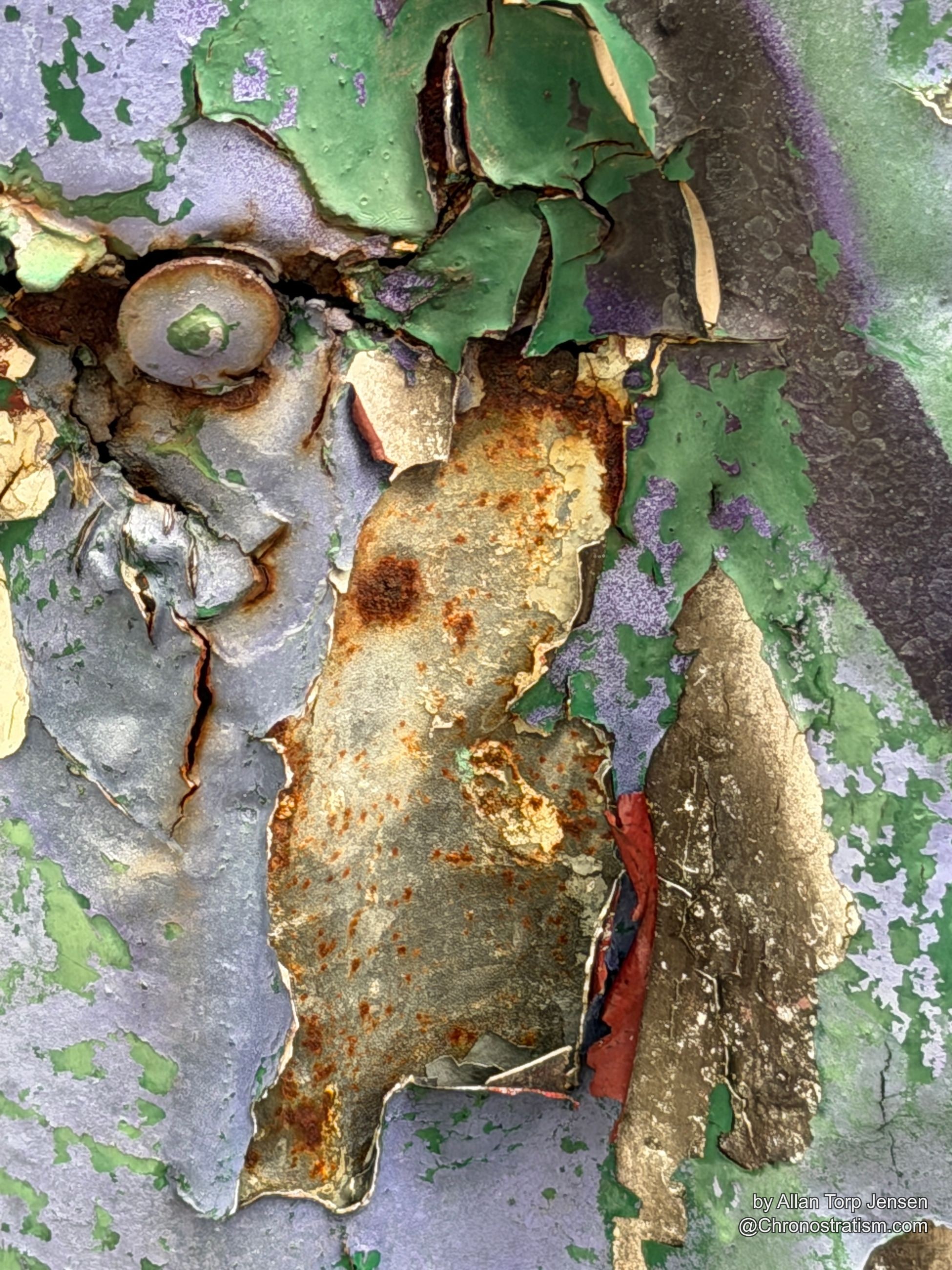 Rust spots speckle a green-painted metal panel, a rusted bolt anchored at its base.