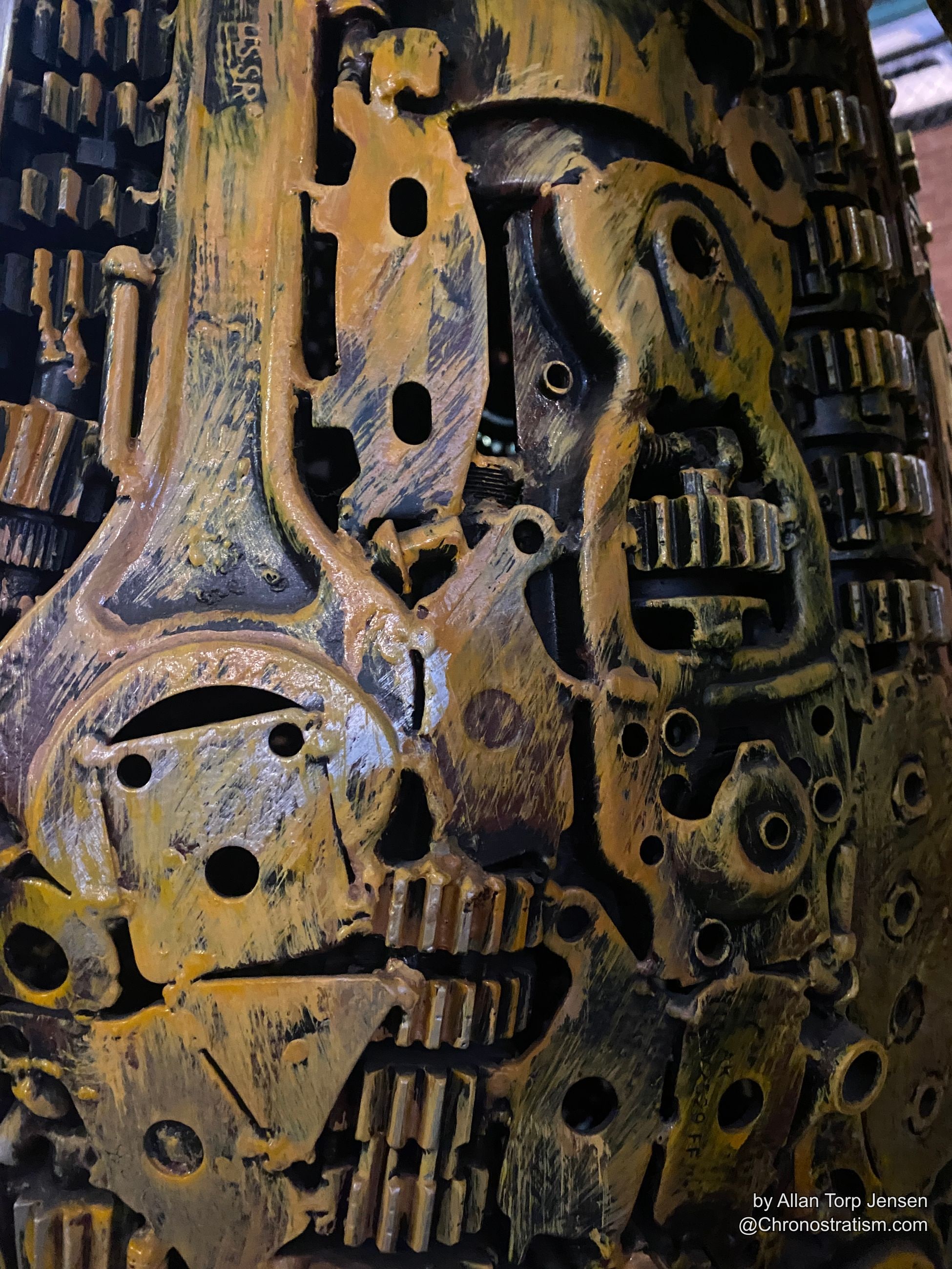 Yellow-painted worn machine parts stamped ‘USSR’, gears half-buried in ochre paint.